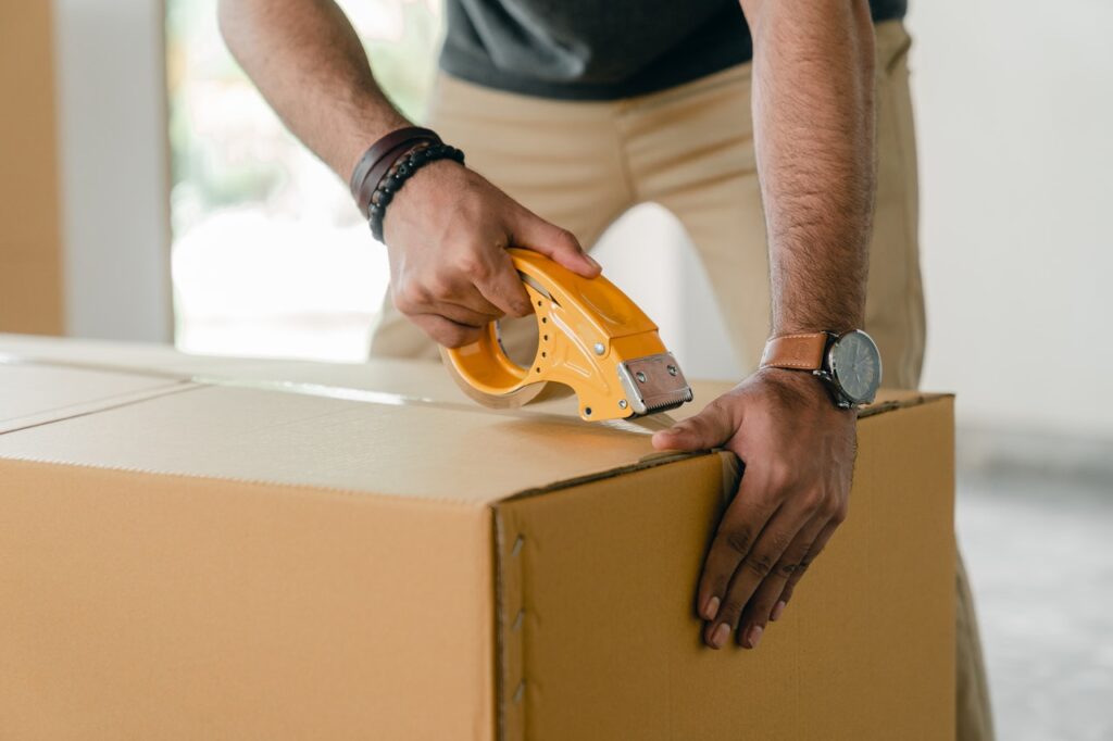 man sealing sustainable packaging box